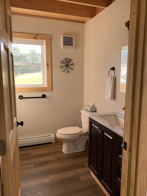 Bathroom features a toilet, window, air conditioning unit, and decorative clock.