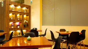 Een restaurant met houten wanden, meerdere tafels en stoelen.