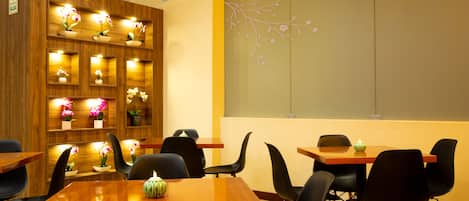 Un restaurante con paredes de madera, varias mesas y sillas.