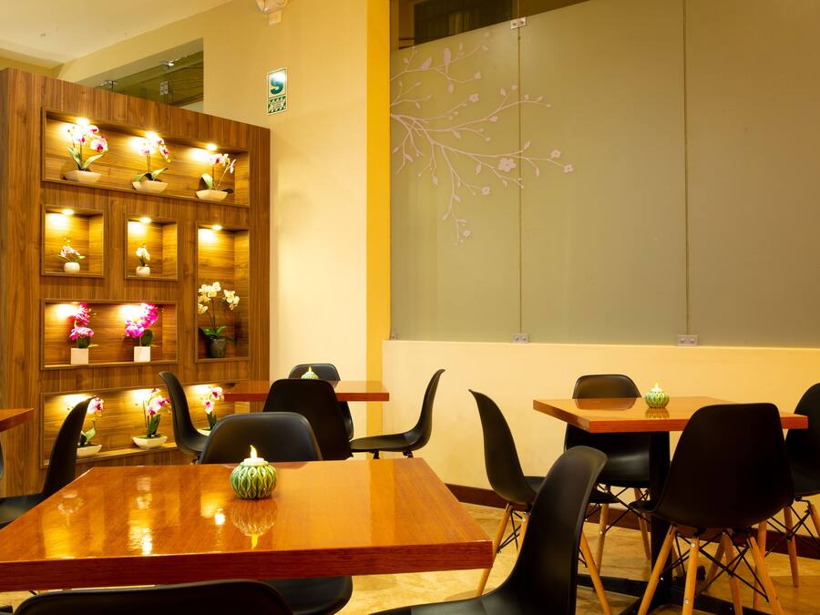 Un restaurante con paredes de madera, varias mesas y sillas.