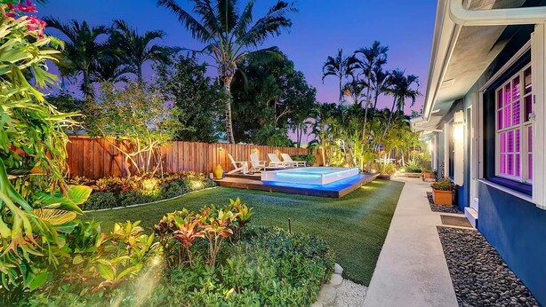 A backyard with a hot tub, artificial grass, and a wooden fence. - Modern Oasis (Oakland Park)