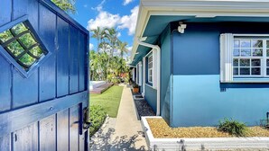 A blue house with a narrow pathway leading to a door. - Modern Oasis (Oakland Park)