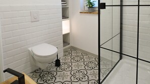 Ein Badezimmer mit Toilette, Waschbecken und Duschkabine mit Glastür.