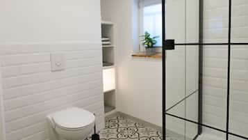 Chuveiro, toalhas de banho, sabonete, papel higiênico