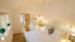 Ein Schlafzimmer mit Bett, Nachttischlampe und einem kleinen Schrank.