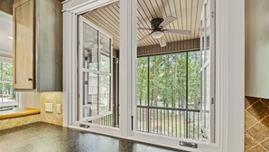 Cucina con un'ampia finestra, una ventola a soffitto e vista sull'esterno.