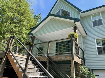 Front porch with rocking chairs and a covered patio to the left.