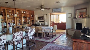 A spacious living room with a dining area, a fireplace, and a large bookshelf filled with books and decorative items. - Green Valley, Gorgeous Mtn Views, Private pool (Green Valley)