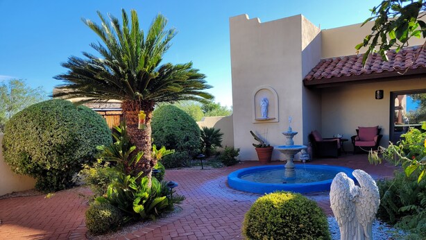 A courtyard with a fountain, palm trees, and a statue. - Green Valley, Gorgeous Mtn Views, Private pool (Green Valley)