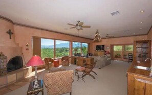 A spacious living room with a fireplace, comfortable seating, and large windows offering a mountain view. - Green Valley, Gorgeous Mtn Views, Private pool (Green Valley)