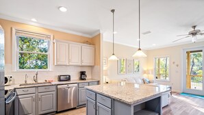 A modern kitchen with granite countertops, stainless steel appliances, and a large island.