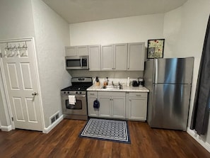 A compact kitchen with a microwave, stove, oven, and refrigerator.