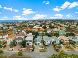 Un barrio residencial con casas, palmeras y vista al océano.