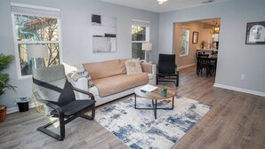 Un salon comprenant un canapé, une table basse, un fauteuil et un ventilateur de plafond.
