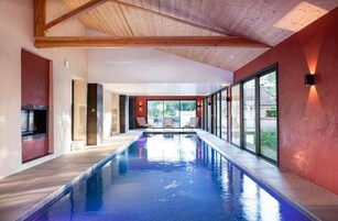 Una piscina cubierta, una piscina al aire libre de temporada, sombrillas