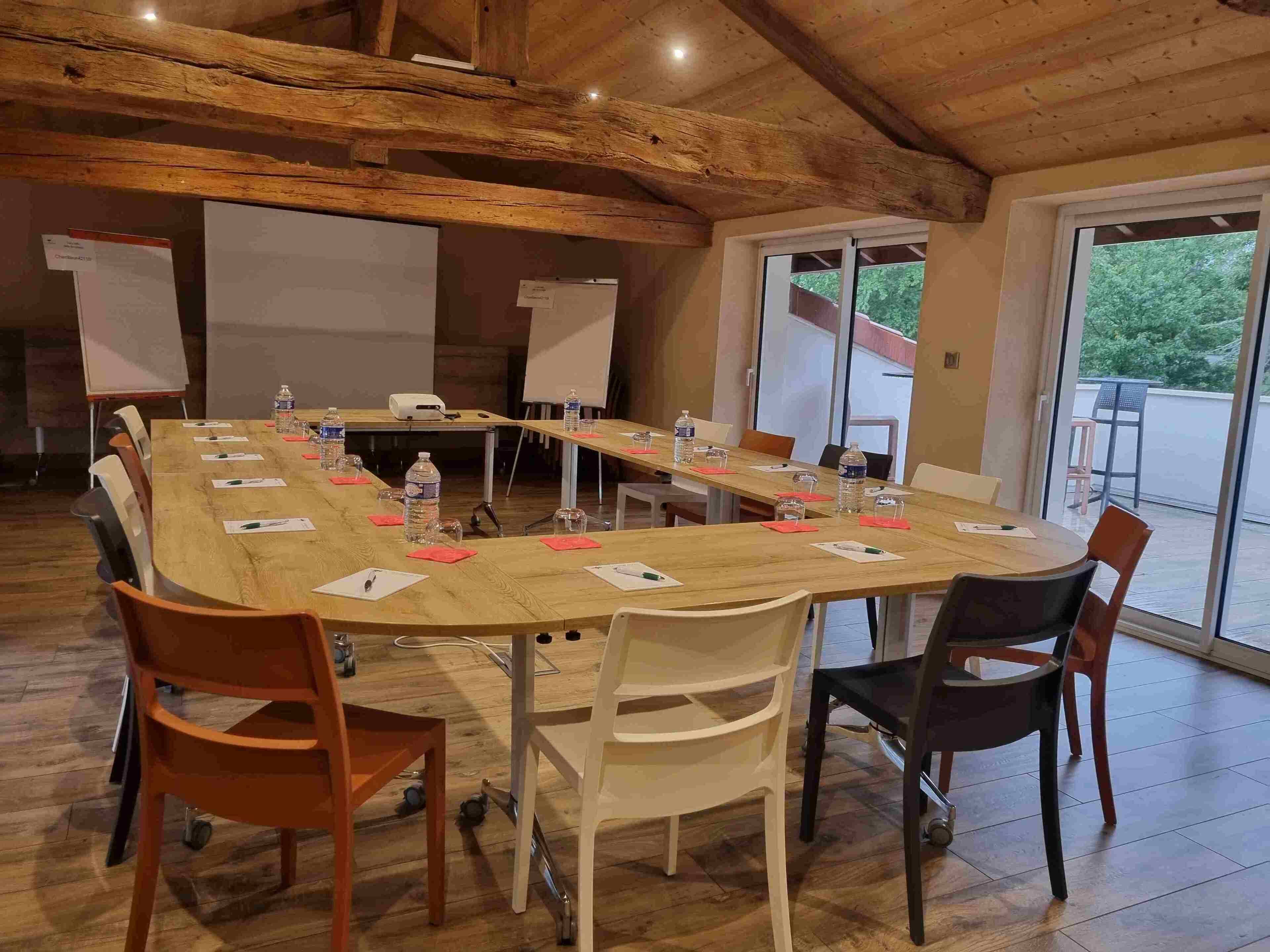 A conference room with a long table, chairs, a projector, and a whiteboard.