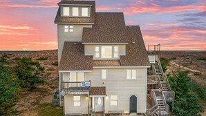 Une maison à deux étages dotée d’un balcon, d’un escalier et offrant une vue sur le paysage environnant.