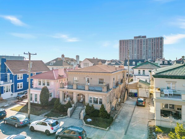 A residential area with various houses, including a two-story building with a balcony and a taller apartment building in the background. - 4BR 3BA Luxe Beach Estate I (Atlantic City)