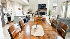 Una cocina amplia con comedor, chimenea y televisor montado en la pared.