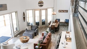 Un amplio salón con sofá, sillas, una mesa de comedor y una zona de cocina con lavamanos y encimera.