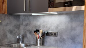 Una cocina moderna con armarios oscuros, electrodomésticos de acero inoxidable y encimera de granito.