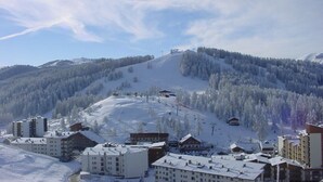 Ein schneebedeckter Berg mit einem Skigebiet, einschließlich Gebäuden und einer Seilbahn.