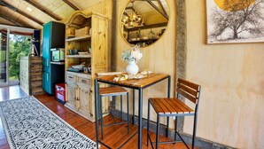 A wooden interior with a dining area featuring a table and chairs, a mirror, and a chandelier. - Tiny Houses of French Village Tranquil & Relaxing (French Village)