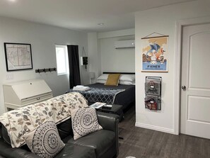 Un dormitorio con cama, escritorio, silla, mapa en la pared y un cartel.