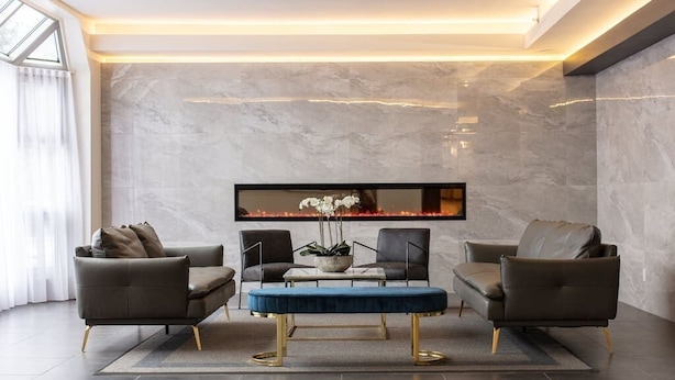 A modern living room with a marble wall, a flat-screen TV, and two leather sofas. - Spacious studio Laval, all included, wifi, parking (Laval)
