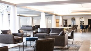 A spacious lobby with leather sofas, a coffee table, and a dining area with chairs and tables. - Spacious studio Laval, all included, wifi, parking (Laval)