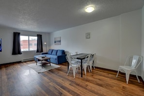 A modern living room with a sofa, dining table, and chairs.