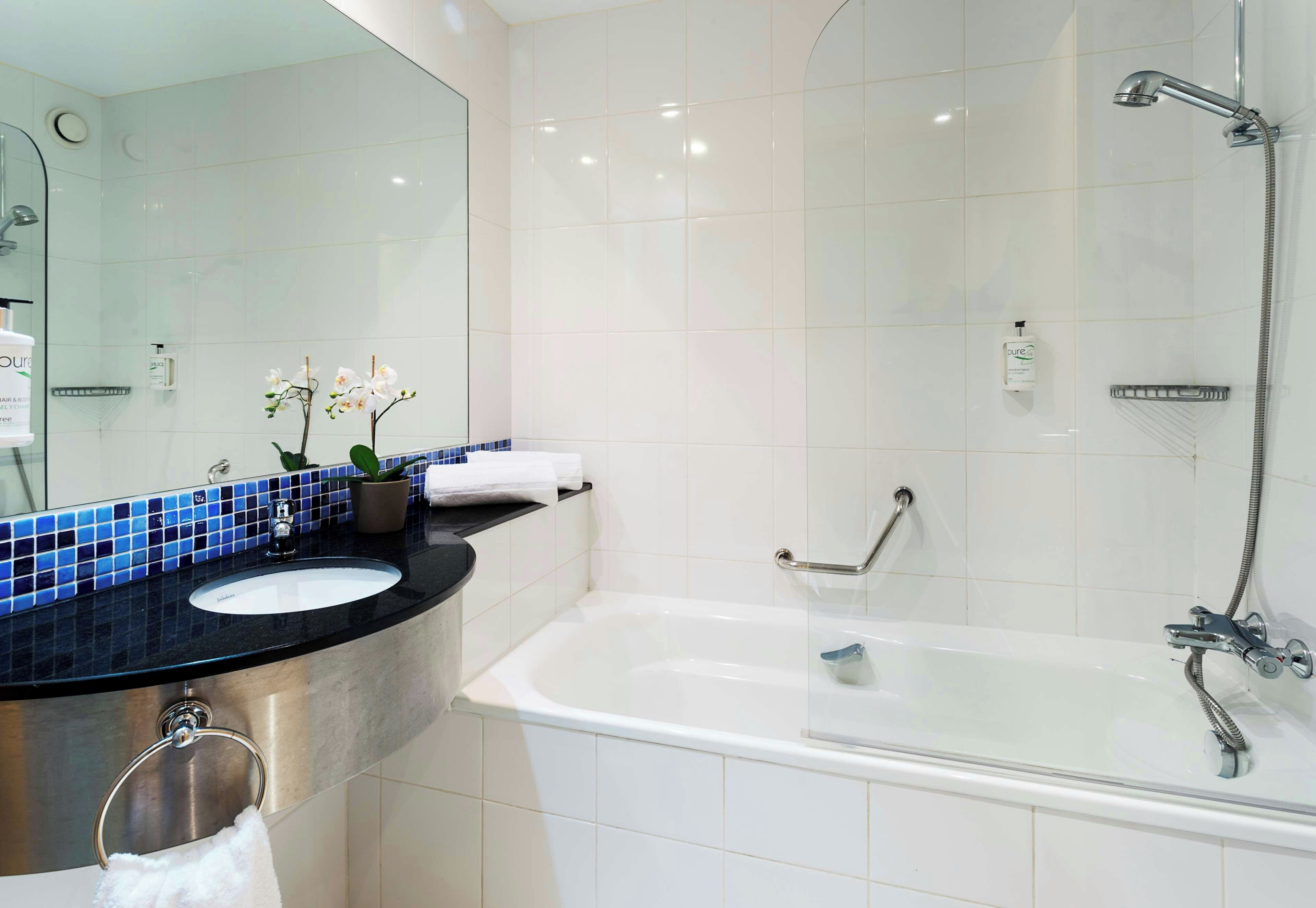Un baño moderno con bañera, lavamanos y ducha.