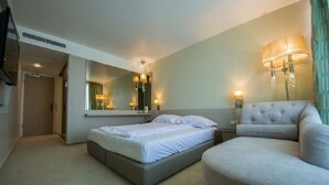 A hotel room with a bed, a nightstand, a lamp, and a mirror. - Turquoise Hotel (Venus)