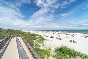 A beach with a wooden boardwalk leading to the shore, sandy beach, and ocean. - First Floor True Blue Golf Condo w/Hot Tub + Beach (Pawleys Island)