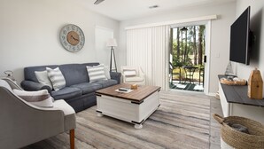 Un salon moderne avec un canapé, une table basse et un ventilateur de plafond.