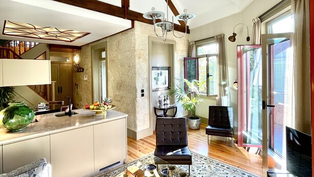 A spacious living area with a large window, a sofa, a coffee table, and a TV.