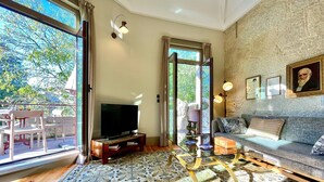 A living room with a television, sofa, and a patterned rug.