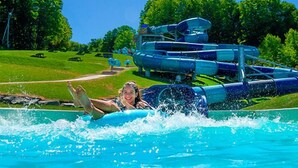 A water park with a water slide and a pool. - Cottage Tranquility family waterfront mountains (Dunham)