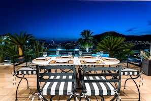 Enjoy al fresco dining with a city view, surrounded by palm trees and a mountain backdrop.
