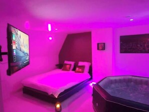 Relax in a stylish bedroom with a comfortable bed, flat-screen TV, and modern decor.