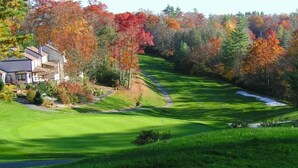Un campo de golf con una casa al fondo.