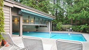 A swimming pool with two white lounge chairs and a small patio area. - Spacious condo in downtown Bellevue (Bellevue)