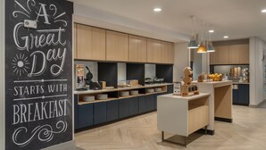 A modern kitchen with wooden cabinets, a central island, and pendant lighting. - Towneplace Suites By Marriott New Philadelphia (New Philadelphia)