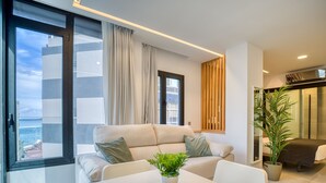 Ein modernes Wohnzimmer mit einer Couch, einem Esstisch und einer Zimmerpflanze.