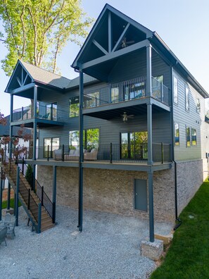 A two-story building with a balcony on the upper floor, a staircase leading to the upper level, and a brick foundation.