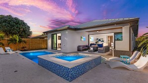 Una casa moderna con piscina, mobiliario exterior y vista al cielo.