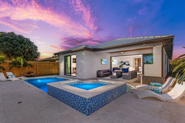 Une maison moderne dotée d’une piscine, d’un espace extérieur aménagé et offrant une vue sur le ciel.