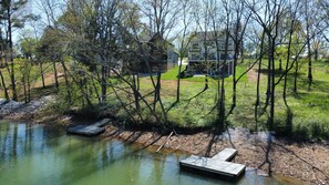 Enjoy a serene lakeside retreat with a tranquil lake, wooden docks, and a comfortable two-story home.