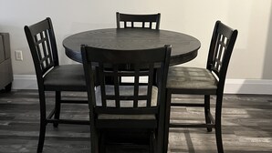 A round dining table with four chairs, a light-colored wall, and a wooden floor. - 5 Mins from Nordic Spa Whitby (Whitby)