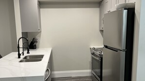 A modern kitchen with a marble countertop, stainless steel appliances, and a herringbone wood floor. - 5 Mins from Nordic Spa Whitby (Whitby)